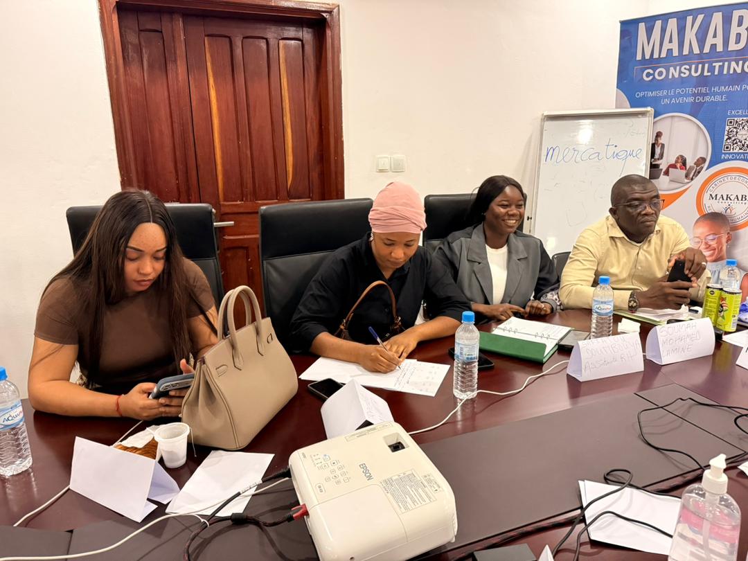 Participantes au travail devant la bannière Makaba Consulting